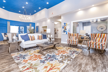 A spacious living room with a blue ceiling and white walls